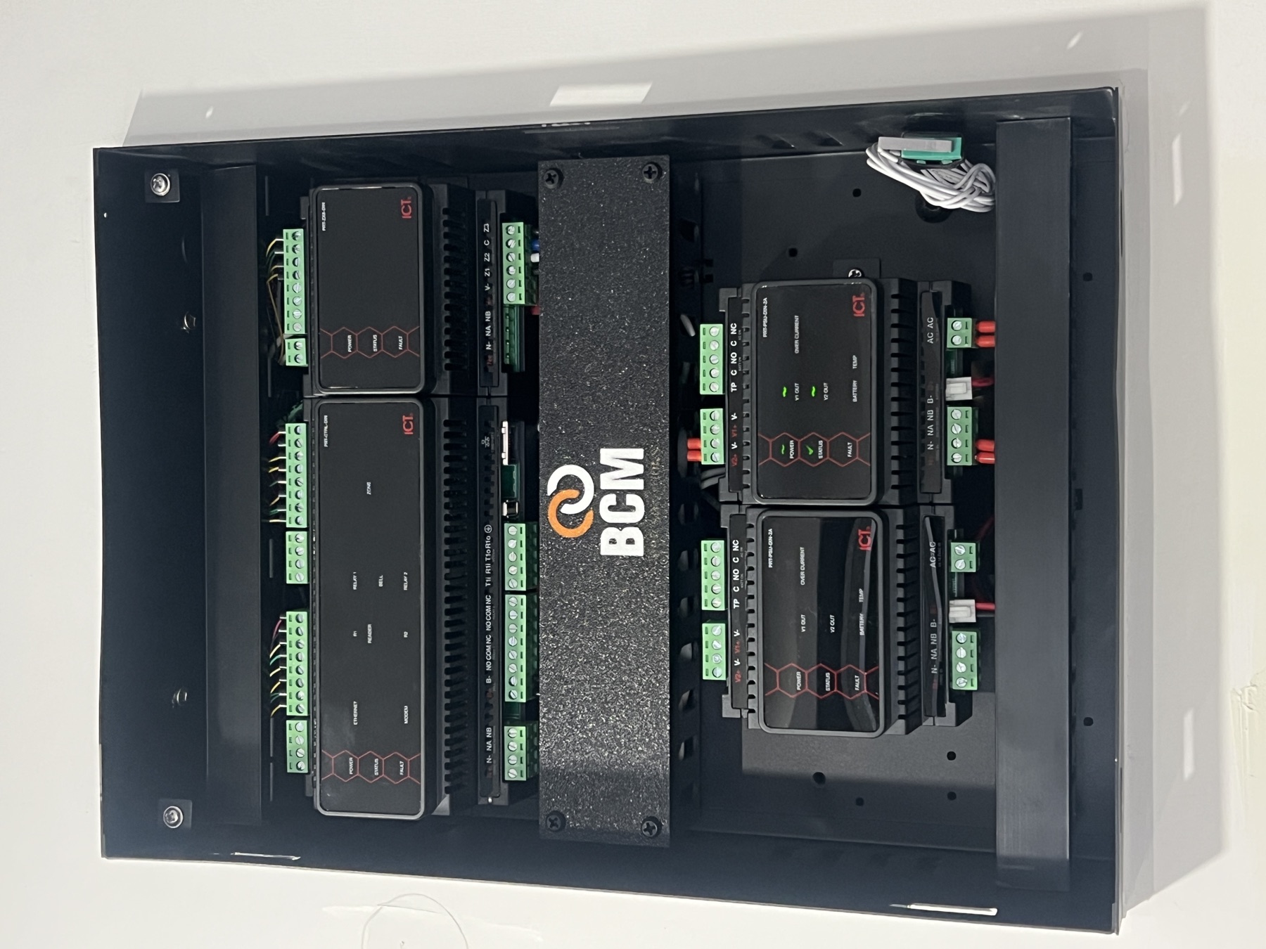Open wall cabinet with ICT modules and a BCM identification plate.