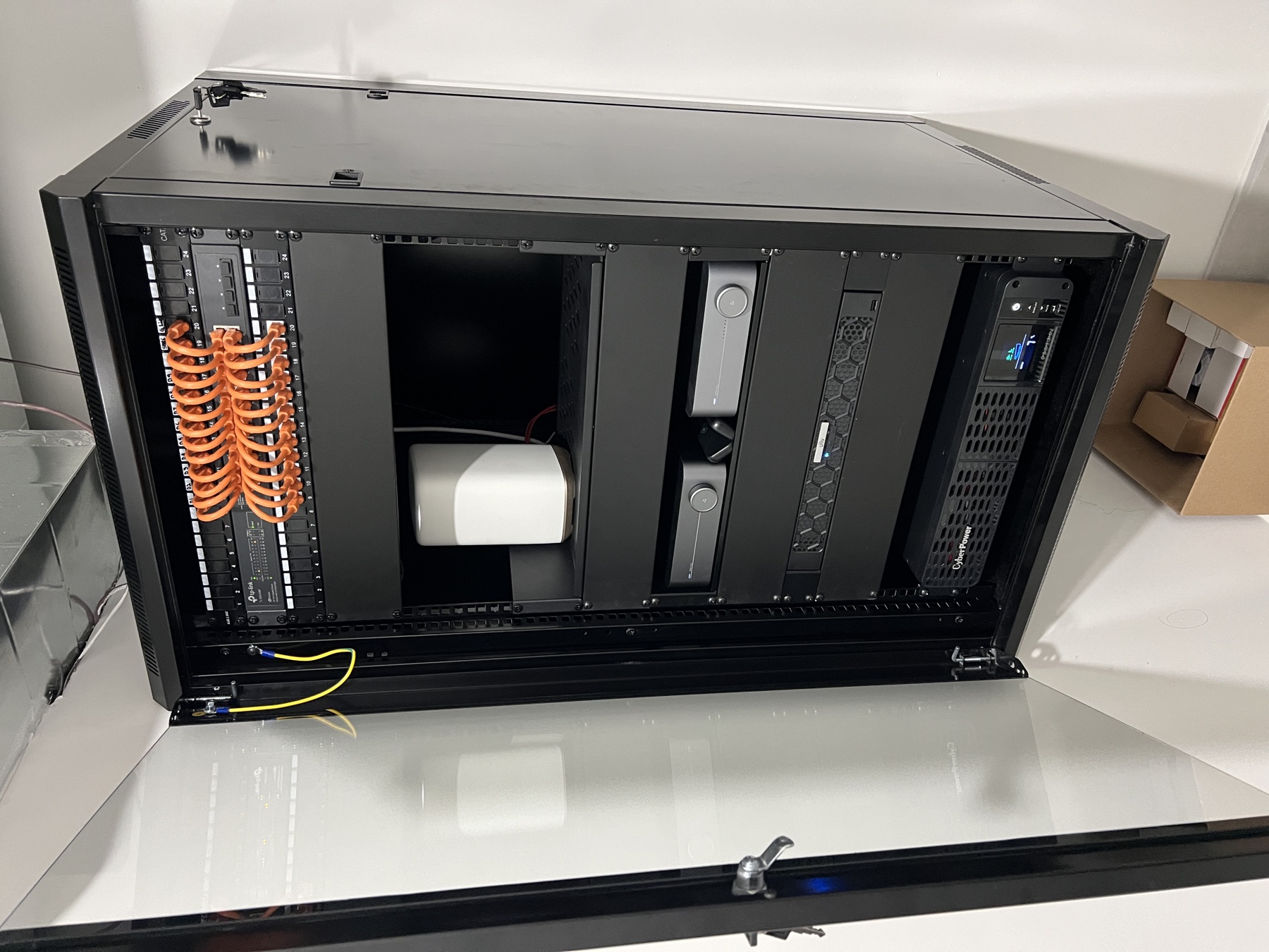 Compact open rack with orange patching and a UPS.