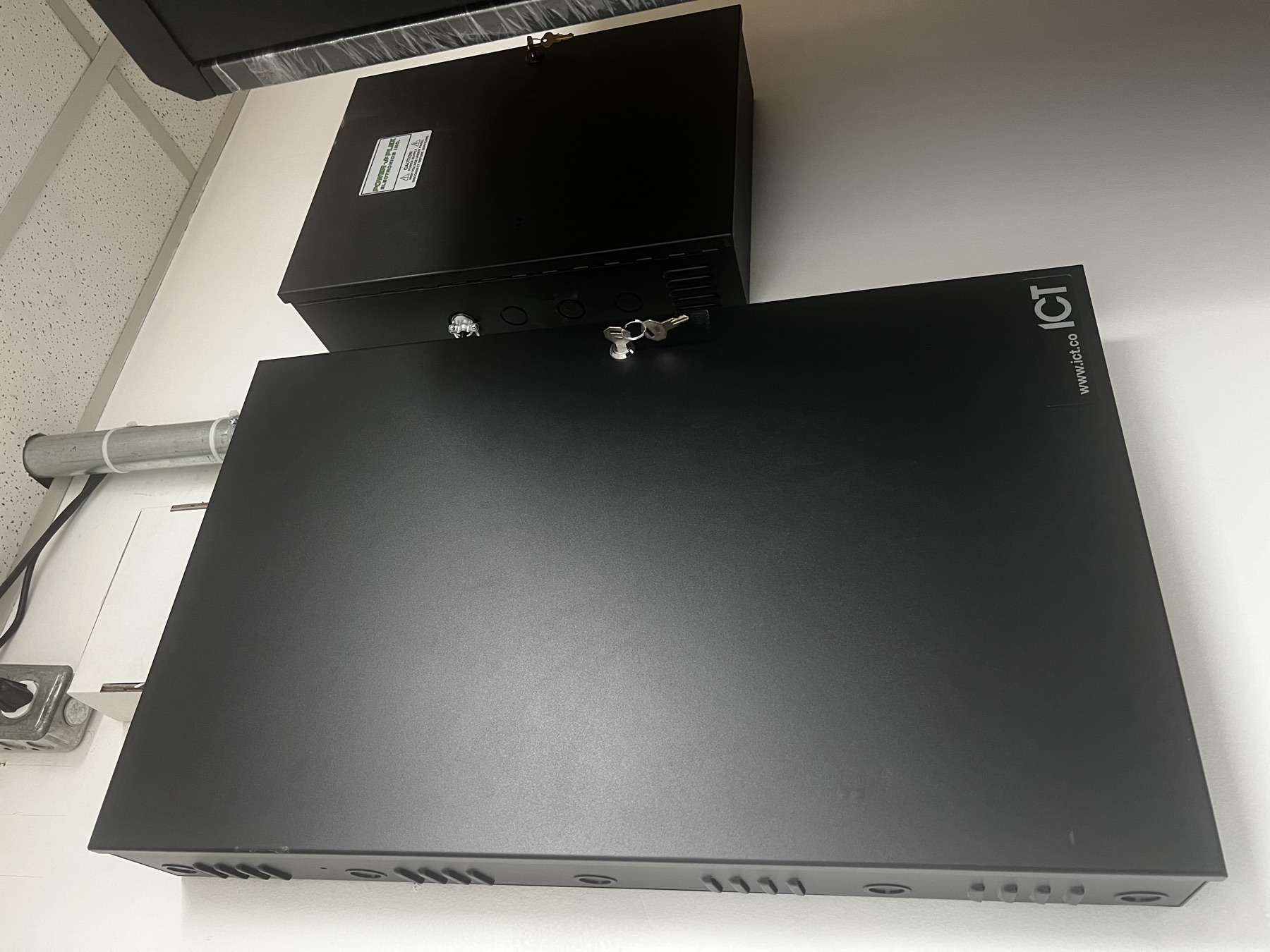 Closed ICT cabinets with conduit into a drop ceiling.