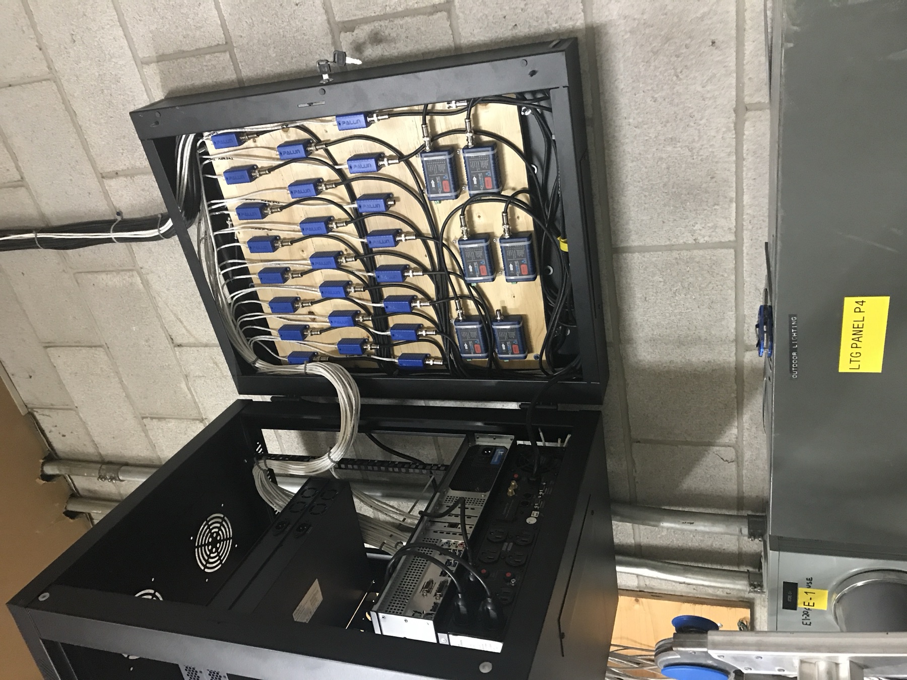 Open wall cabinet with dressed video and network cabling.