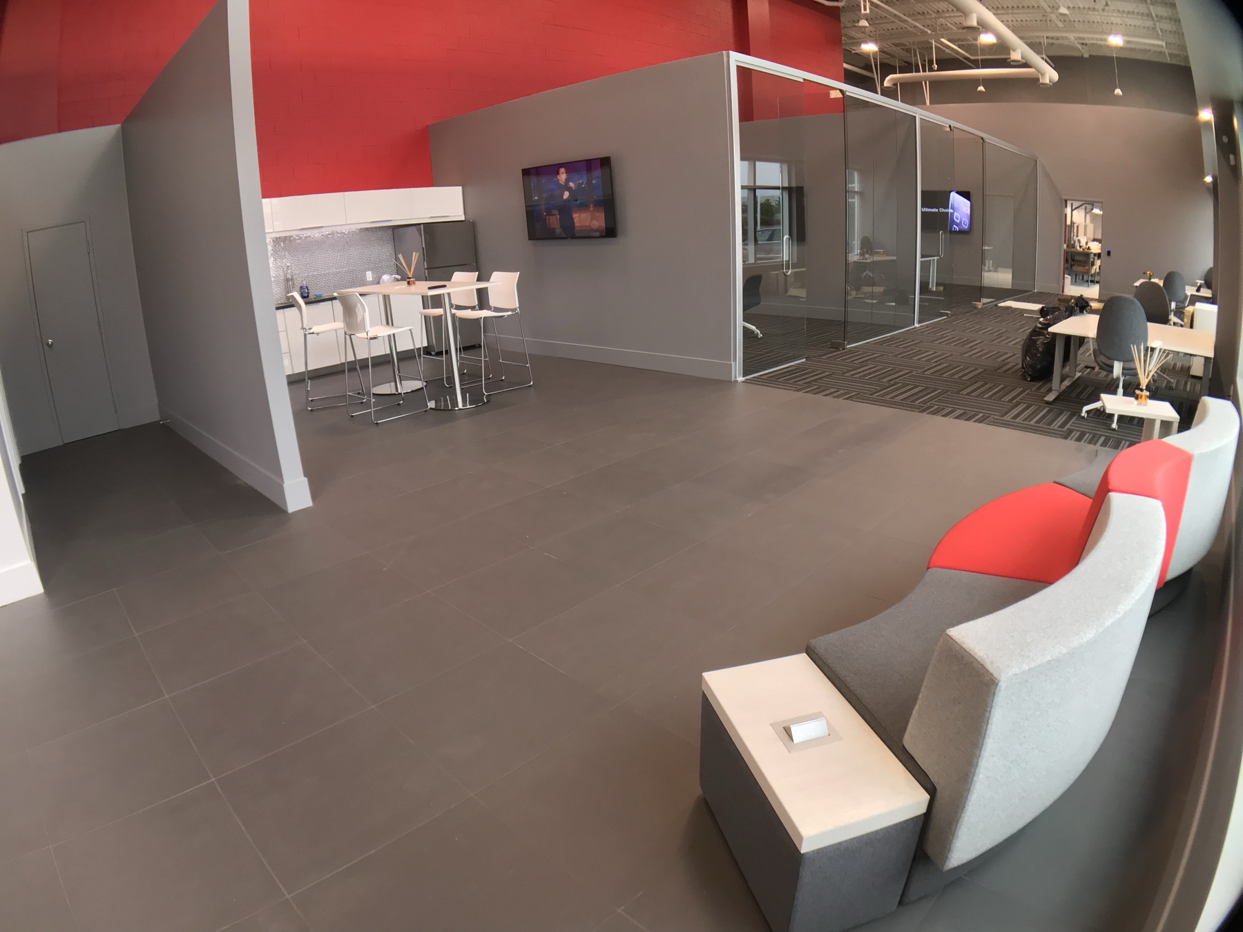 Occupied commercial office with glass rooms and a lounge.