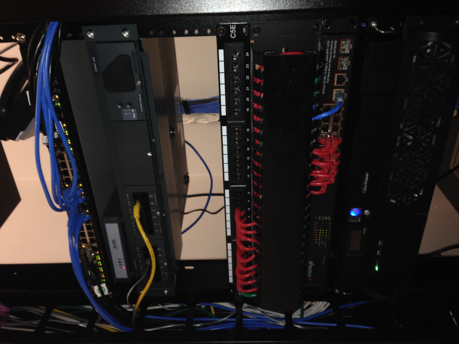 Open-frame rack with patching, PoE switch, and a UPS.