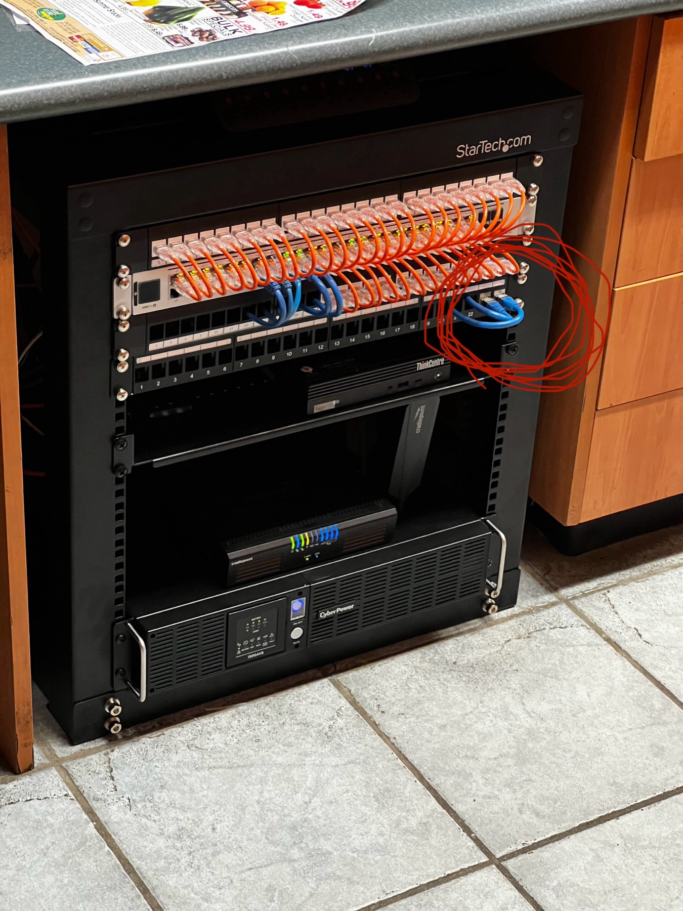 Small under-desk rack with patching and a UPS.