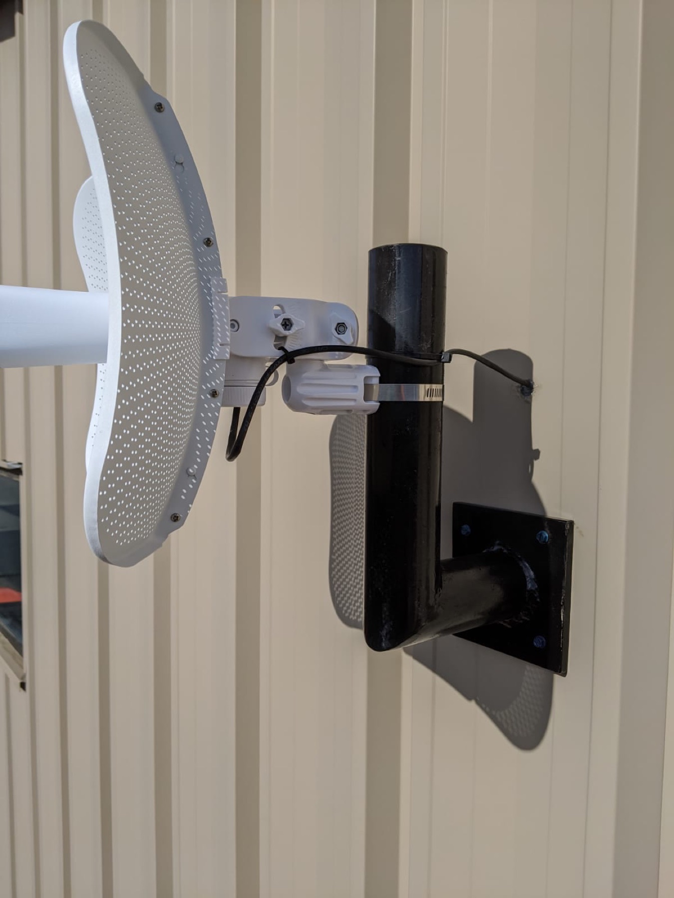 Wireless bridge mounted on corrugated metal siding.